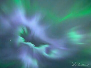 Green and purple aurora dance in the sky. 