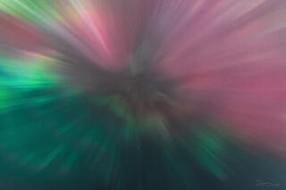 An auroral corona bursting with rays shining down.