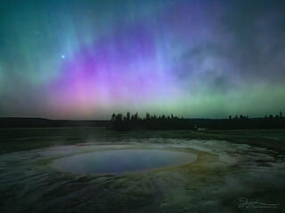 Opal pool with aurora in the sky in Yellowstone.