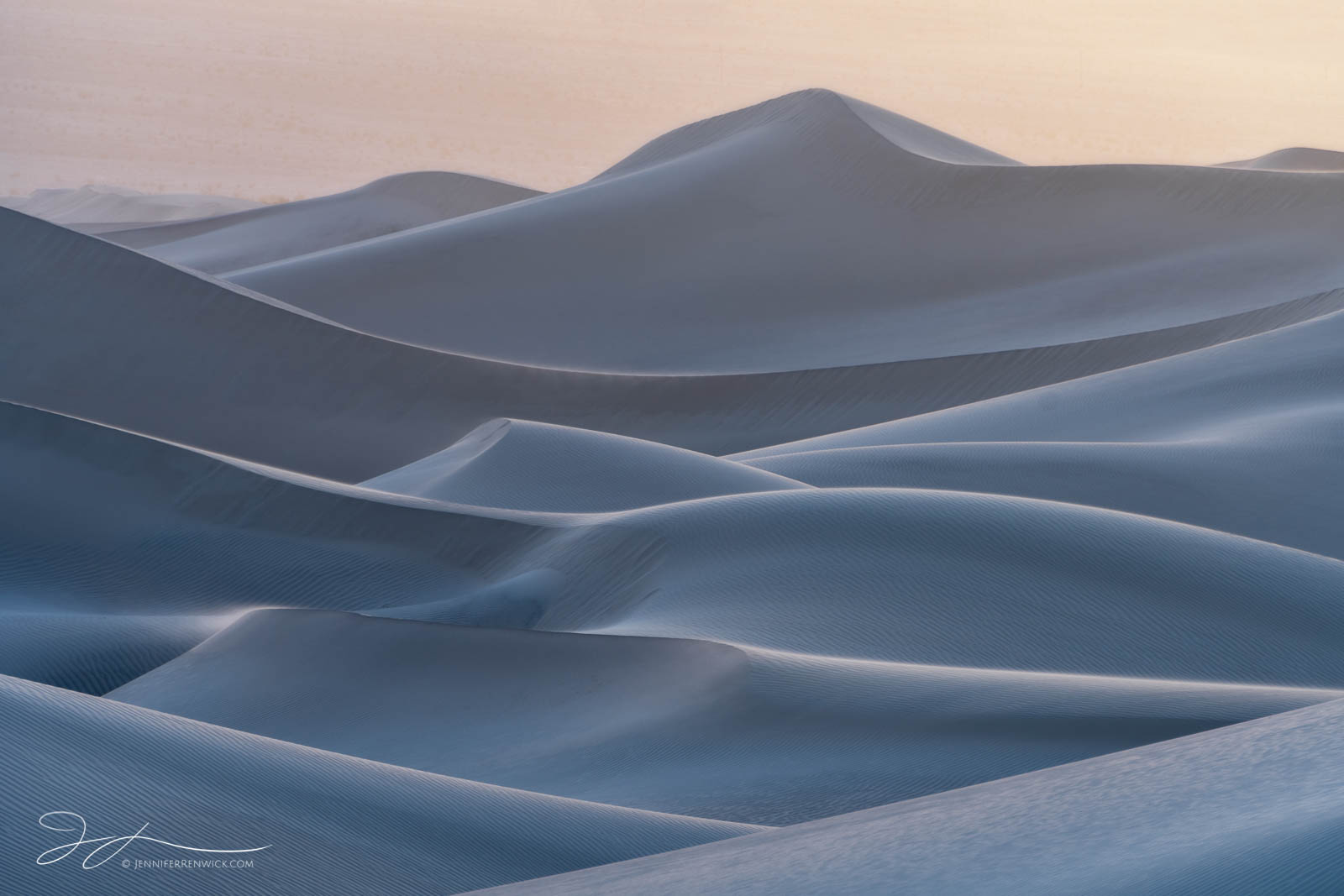 Dunes take on a blue hue after sunset during a windstorm.