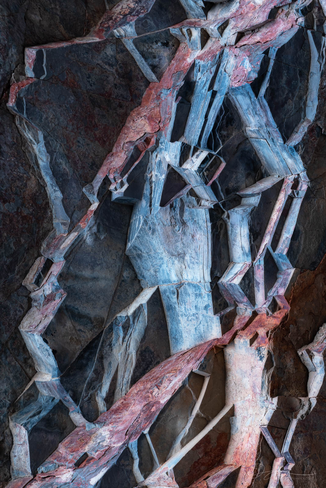 Ancient layers of blocky rocks create geometric shapes on a canyon wall.