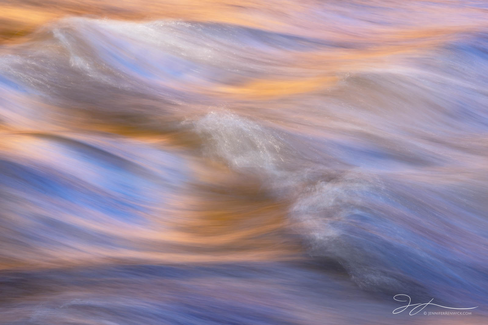 Water reflects the sky and canyon light in the Virgin river in Zion National Park.
