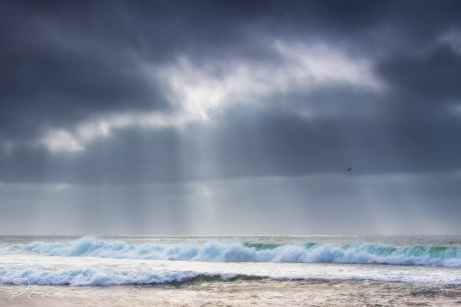 A storm clears as light beams shine down to the ocean near La Jolla, California.