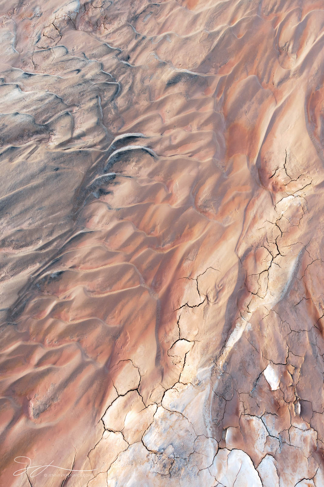 Mud cracks and sand ripples meld together on the desert floor.