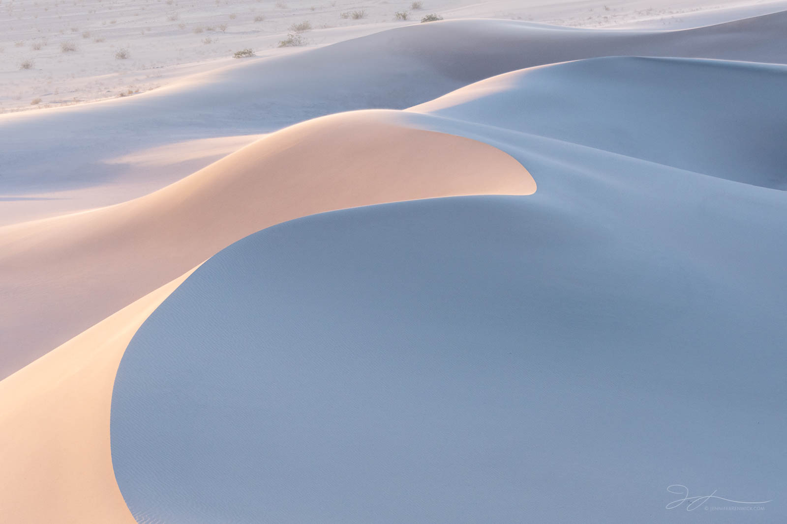 Sand dunes blush with the last light just after sunset.