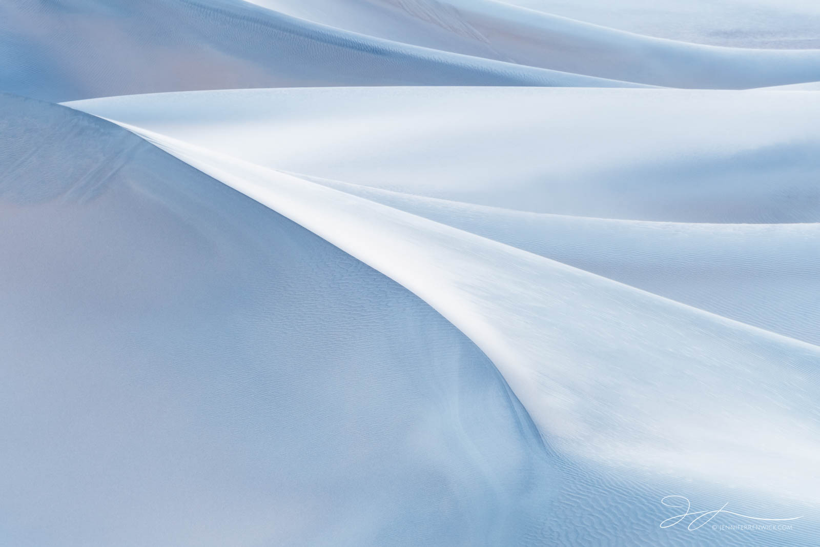 Pristine dunes seem to fold into each other during soft twilight light.