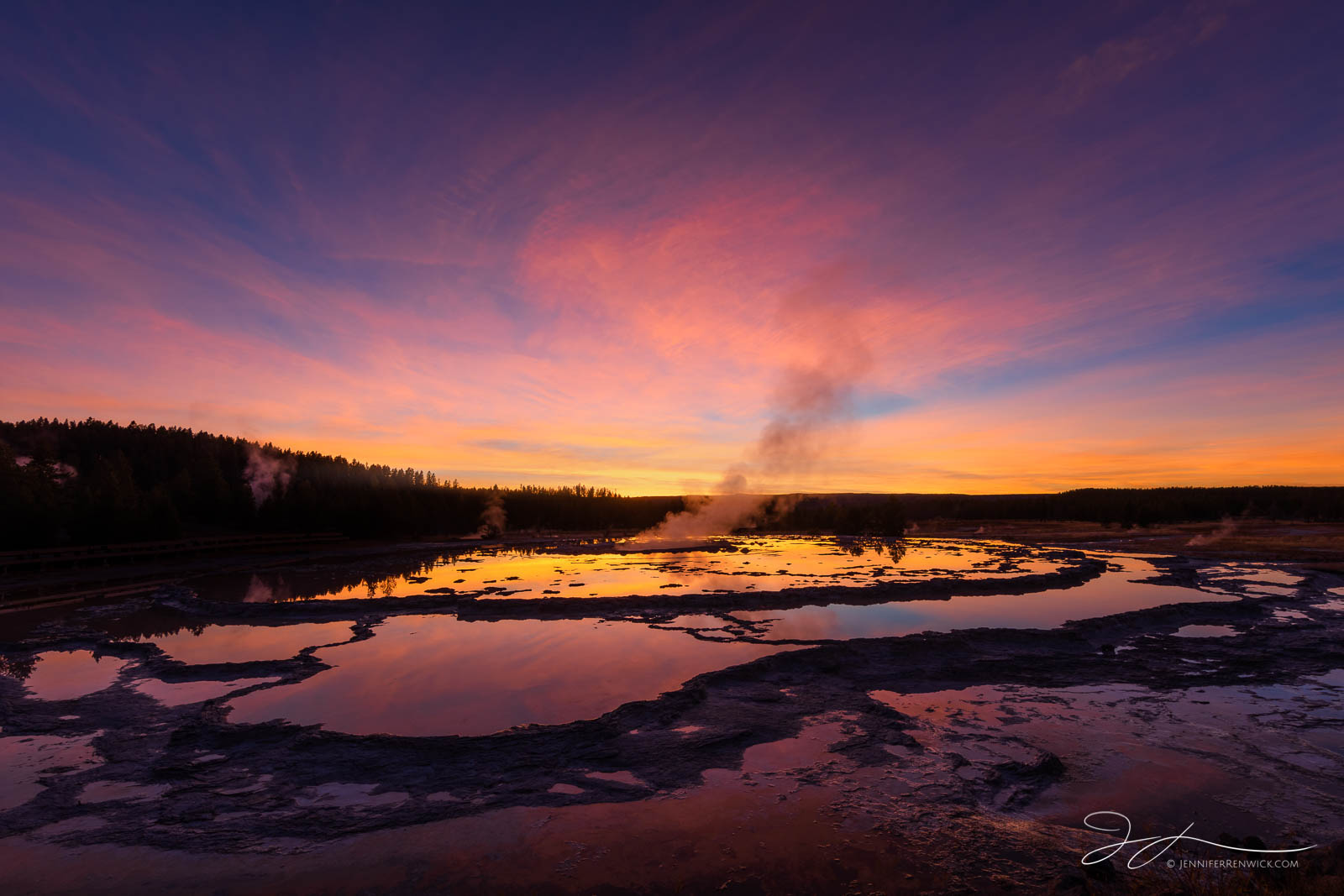 Colors from a vibrant sunset sky reflect into the pools and terraces of Great Fountain Geyser in Yellowstone National Park.