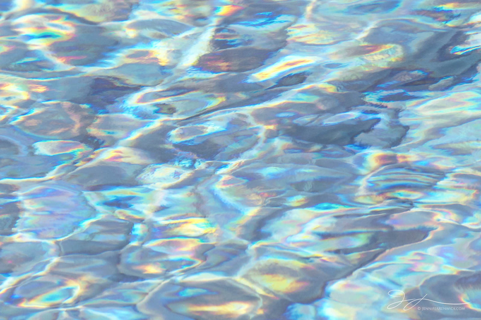 Water creates a holographic effect as it interacts with the light on the disturbed surface of a hot spring pool in Yellowstone...