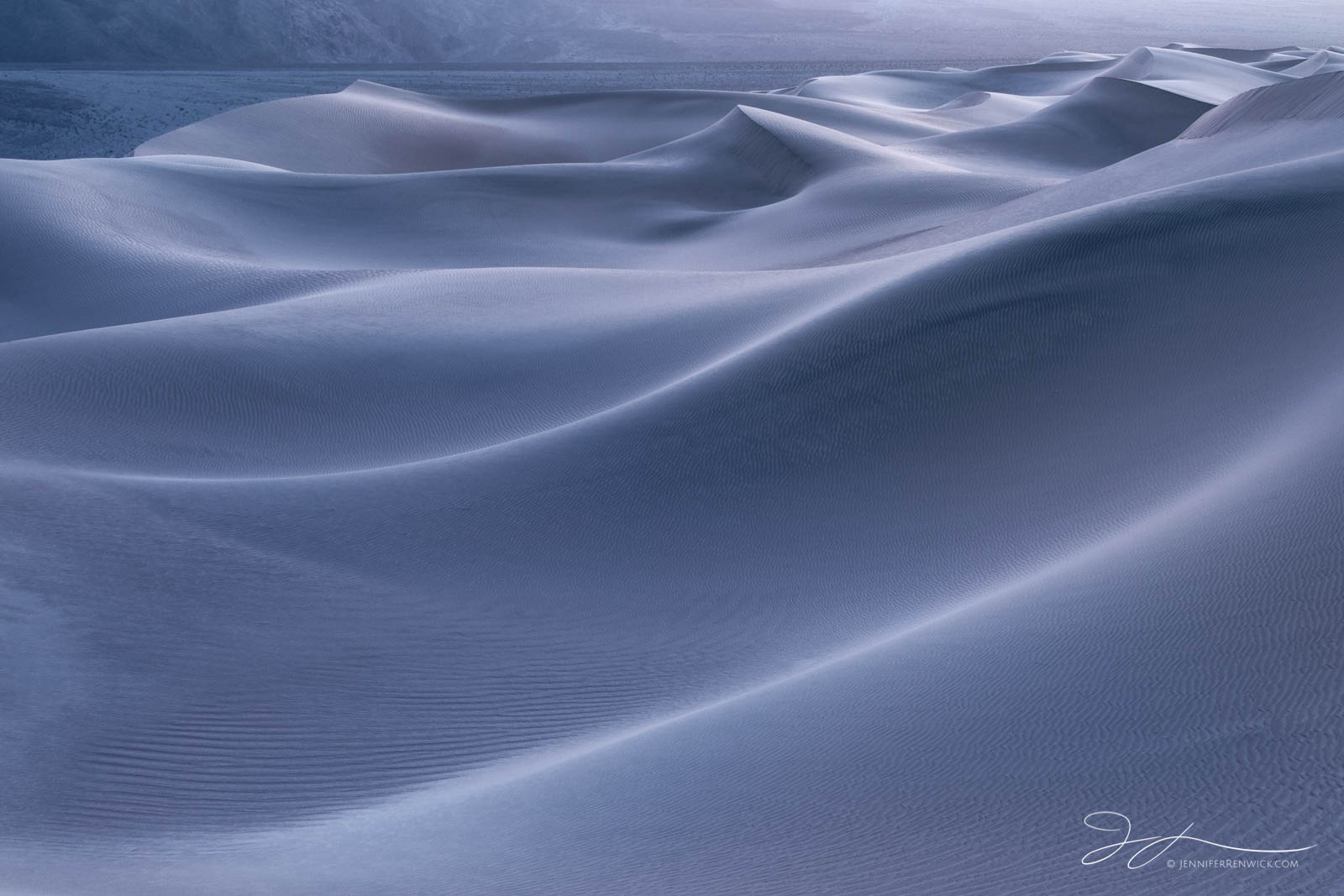 Blue and silver tones accent the sand dunes during evening twilight.
