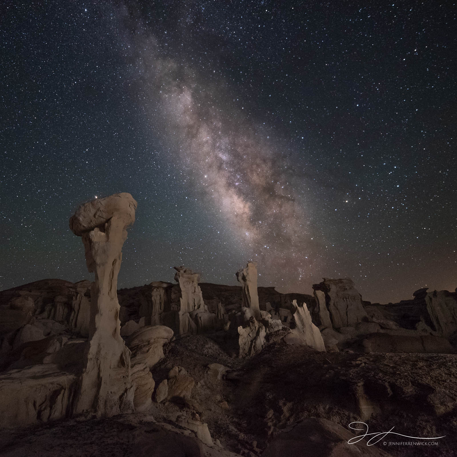 The Milky Way stretches over an area of badlands in New Mexico.