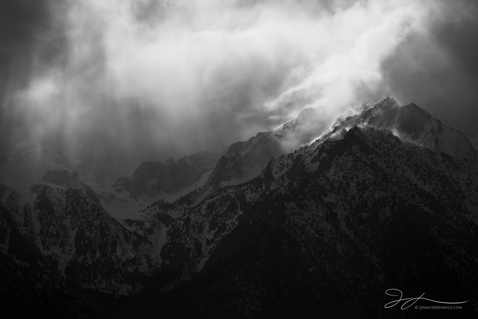 A winter storm allows a pocket of the sun to shine over the Eastern Sierra mountains.