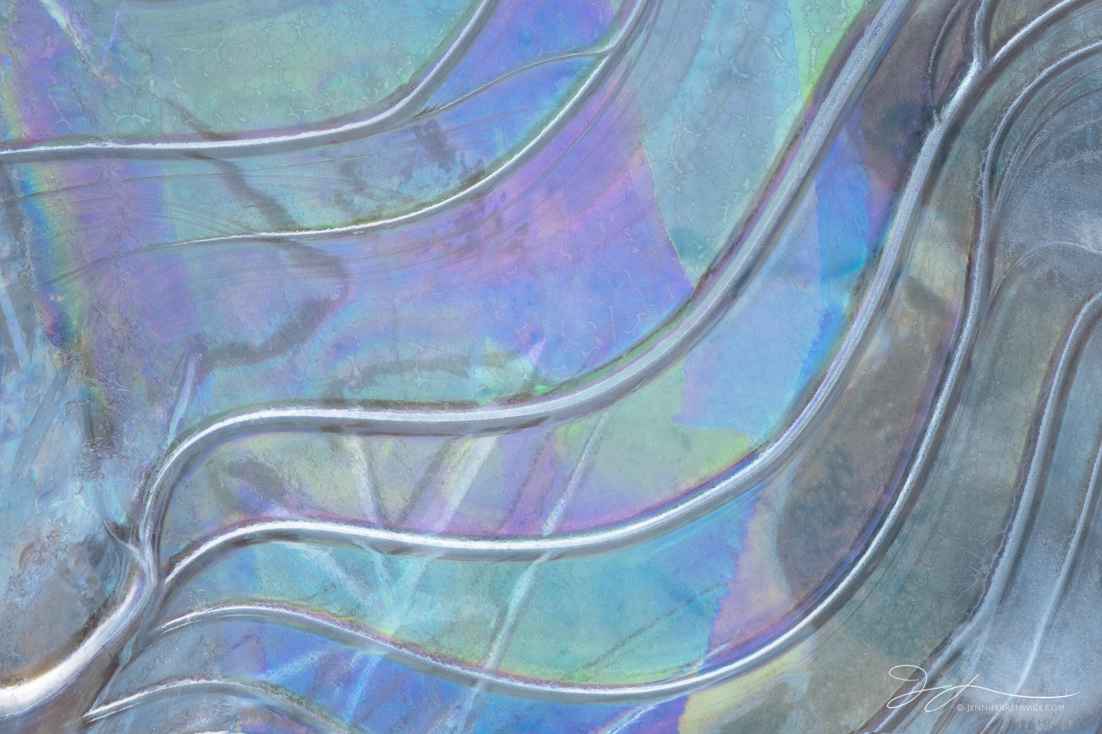 An ice pattern in a frozen canyon puddle mesmerizes with color and lines.