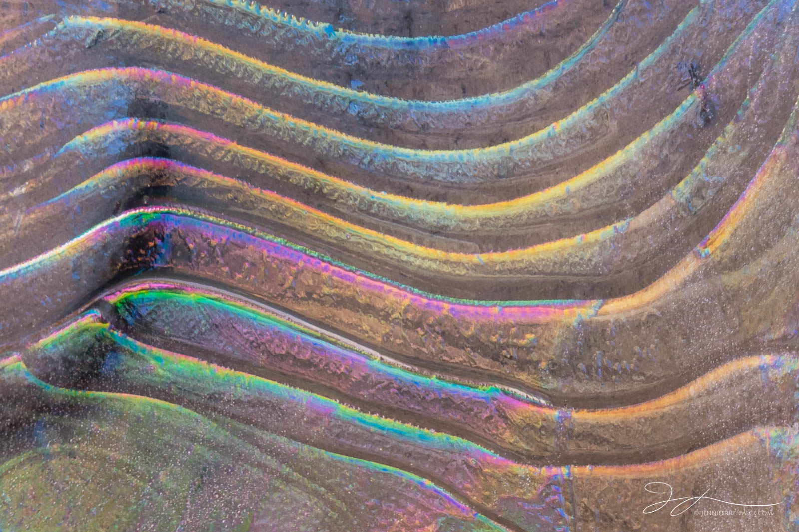 Striated ice in a canyon picks up natural light and reflects vibrant colors.