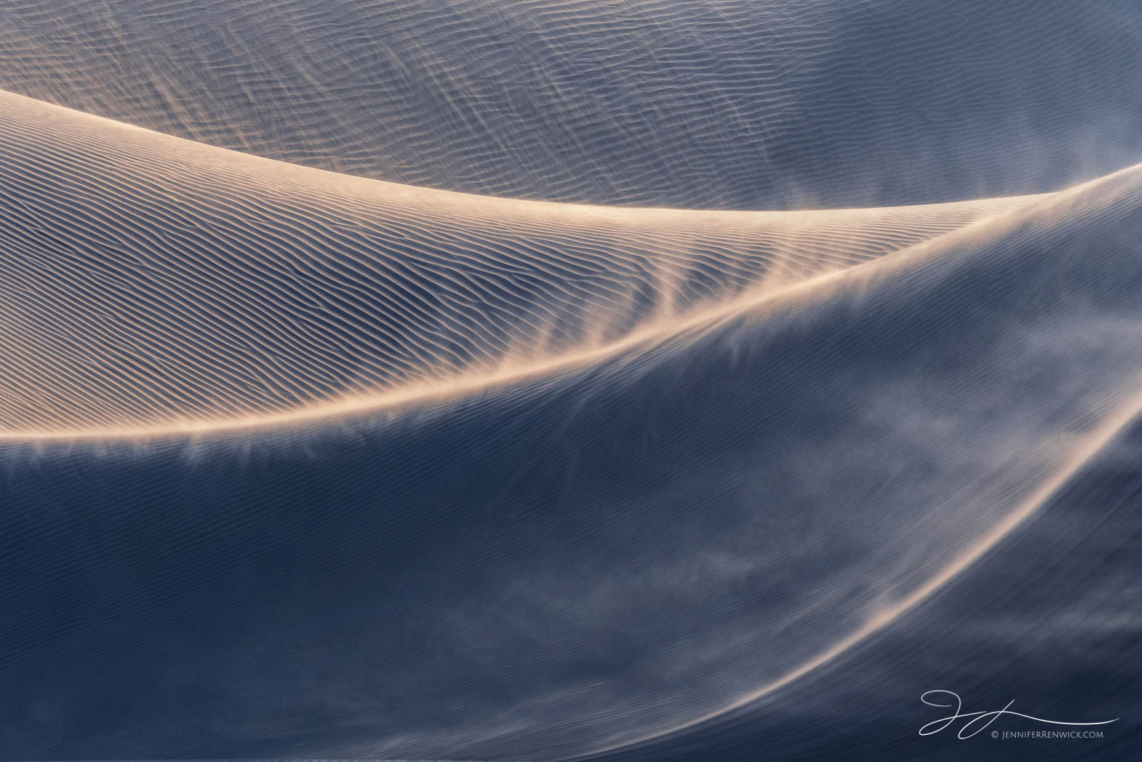 Wind reshapes the surface of a set of dunes during a late afternoon windstorm.
