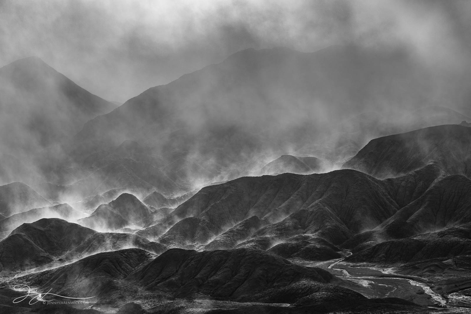 Sun backlights steam rising up from the badlands after a night of rain in Death Valley National Park.  This image is part of...