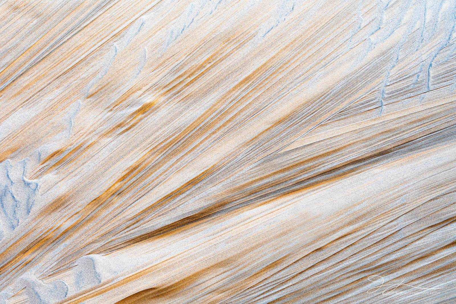 A texture in the sand on the desert floor resembles a wood grain pattern.