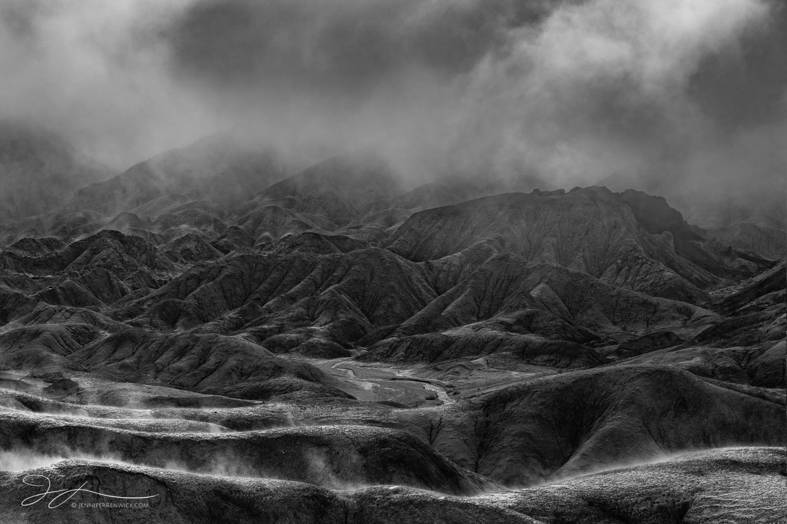Sun breaks through and clears the fog after a rainy night in the badlands of Death Valley National Park.  This image is part...
