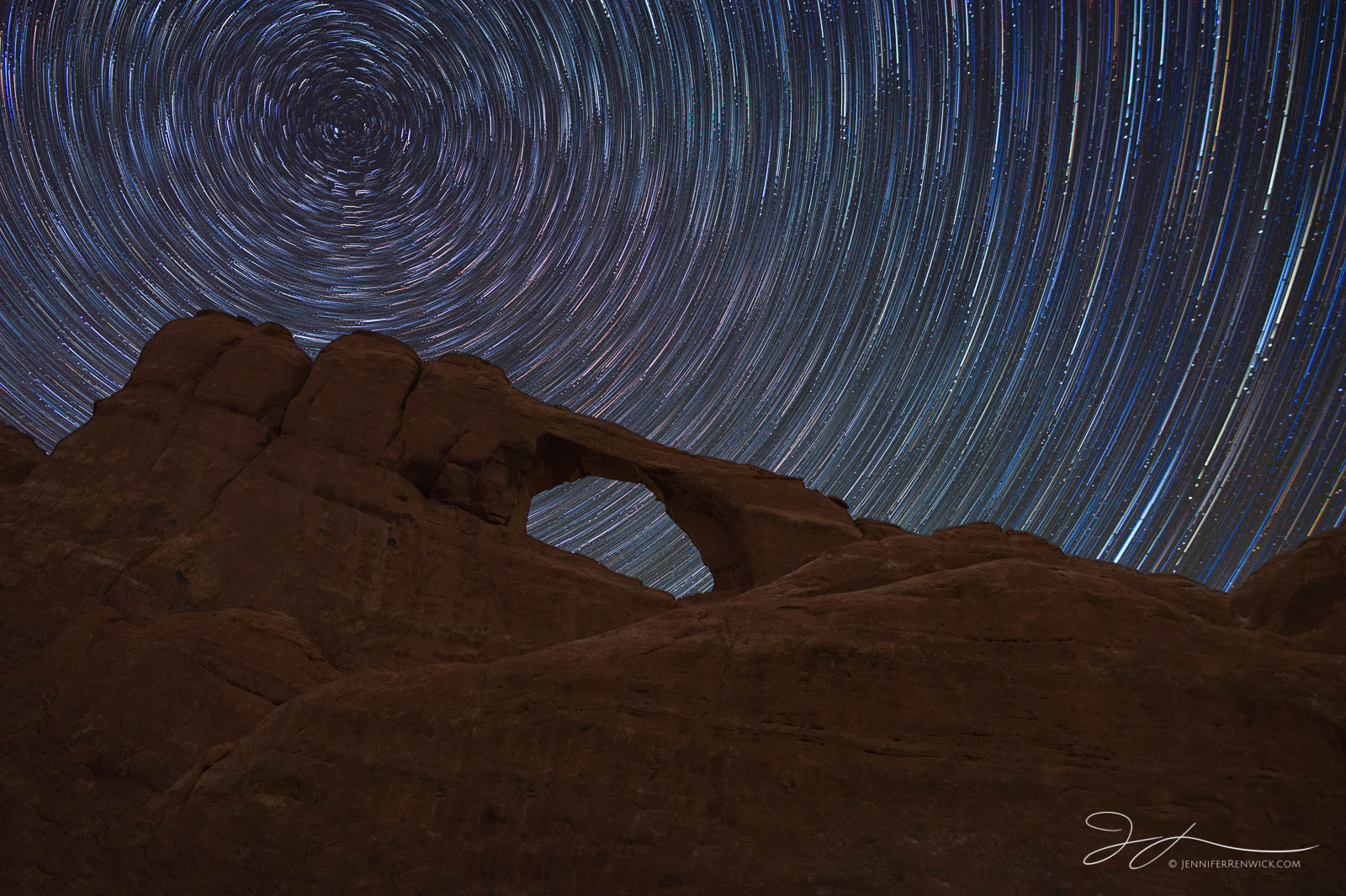 Colorful star trails form a vortex above Skyline Arch in Arches National Park.